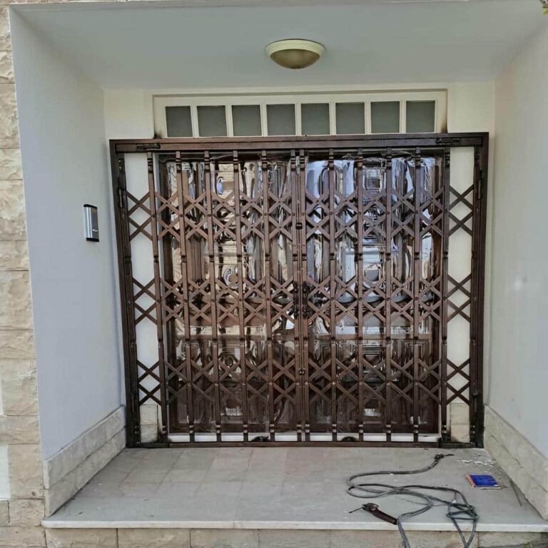 درب و حفاظ آکاردئونی نصب‌شده روی دیوار در اصفهان